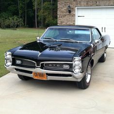 a black car parked in front of a garage