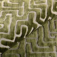 a close up view of a green and white fabric with an interesting design on it