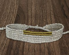 a white and gold bracelet on a wooden table