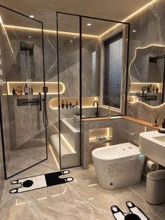 a modern bathroom with grey marble walls and flooring is lit by recessed lighting