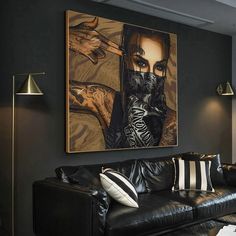 a living room filled with furniture and a painting hanging on the wall over a black couch