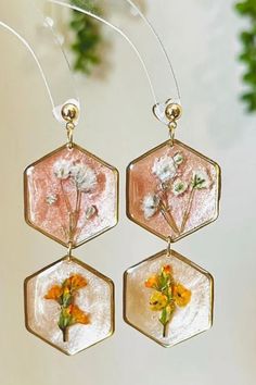 three glass hexagons with flowers hanging from them