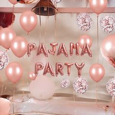 there are balloons that say pajama party and donuts hanging from the ceiling