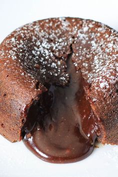 a chocolate lava cake is cut in half on a white plate