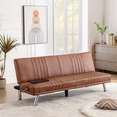 a brown leather couch sitting on top of a white rug in a living room next to a potted plant