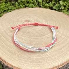 Handmade friendship bracelet, made from waxed cord in coral pink, sky blue, white and light beige, with decoration of silver lined seed beads. The bracelet fastens with a sliding knot so you can adjust the size to fit perfectly. Minimum diameter when it's closed is 15-16cm. and the fastening threads allows it to be opened to around 28-30cm. The waxed cord thickness is 1mm. If you need specific size please let us know, custom orders are welcome, feel free to contact us with any questions. All of our bracelets are 100% handmade, we don't sell anything that is not crafted by us. Created with love for you! Pink Nylon Cord Bracelets For Beach, Casual Pink Beaded Bracelets With Adjustable Cord, White Friendship Bracelets With Waxed Cord, White Waxed Cord Friendship Bracelets, Pink Adjustable Friendship Bracelets Made Of Nylon Cord, Adjustable Pink Friendship Bracelets Made Of Nylon Cord, Adjustable Pink Friendship Bracelets In Nylon Cord, Resizable Nylon Cord Friendship Bracelets For Beach, Beach-style Resizable Nylon Cord Friendship Bracelets