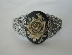 This beautiful silver plated filigree cuff bracelet has a rose cameo setting with silver plated filigree accents on the sides. Adjustable. Silver Gothic Bangle, Adjustable Victorian Cuff Bracelet For Formal Occasions, Gothic Style Adjustable Formal Jewelry, Filigree Metal Cuff Bracelet Gift, Metal Filigree Cuff Bracelet As Gift, Metal Filigree Cuff Bracelet Gift, Antique Silver Bangle Jewelry Gift, Antique Silver Bangle Jewelry For Gift, Handmade Victorian Bracelets For Wedding