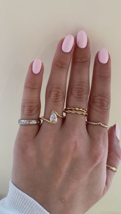 a woman's hand with pink manicures and rings on her left hand