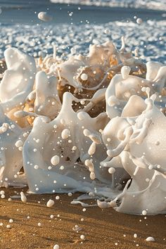 some white foam on the sand and water