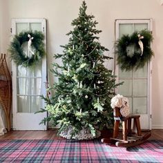 a small christmas tree sitting next to a rocking chair