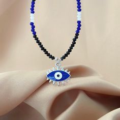 This whimsical piece combines the earthy charm of a beaded necklace with the mystic allure of gemstone jewelry, creating a unique and sparkly accessory. The intricate beads, add a touch of spirituality to your ensemble. The evil eye pendant, a symbol of protection, takes center stage, warding off negative vibes with its watchful gaze. Wear this enchanting necklace not just as a fashion statement, but as a talisman that blends style and spiritual significance in one harmonious accessory W H Y  _ I'M _  S P E C I A L 📿 Handmade  to Order from a small business  🤗Meticulously handcrafted with tiny glittering, shining, crystal beads 🧿 Evil Eye Protection Charm 💦 Waterproof  🌟 Lightweight  🛡️ Hypoallergenic ️Statement,elegant, perfect for everyday wear or for special occasions 🛩️ Fast shi Symbolic Beaded Jewelry For Festivals, Symbolic Festival Beaded Jewelry, Beaded Pendant Charm Necklace Gift, Symbolic Gemstone Bead Necklaces For Gifts, Beaded Pendant Charm Necklace For Gift, Gift Beaded Pendant Charm Necklaces, Spiritual Charm Necklaces With Colorful Beads For Gift, Beaded Amulet Necklace As Gift, Gemstone Beads Amulet Crystal Necklaces For Jewelry Making