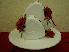 three white plates with red roses on them and the word love written on one plate