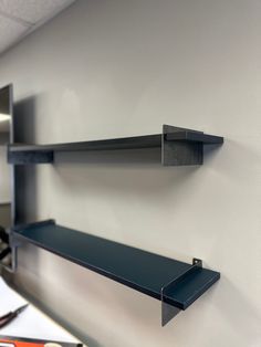 two black shelves are hanging on the wall