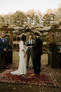 a bride and groom exchanging vows at their outdoor ceremony