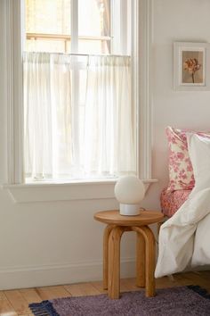 a bedroom with a bed, nightstand and window