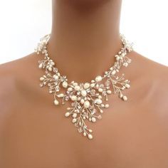 a woman wearing a necklace with pearls on it