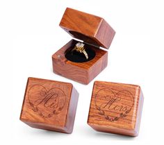 three wooden boxes with wedding rings inside one box and the other in an open box