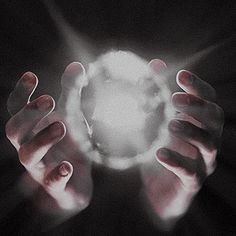 two hands holding a glowing object in the dark