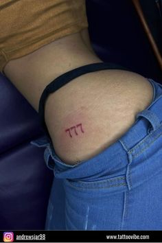 a woman's lower back tattoo with the word pi on it in red ink