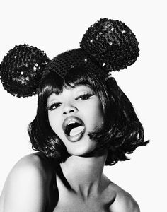 a black and white photo of a woman wearing minnie mouse ears with her mouth open