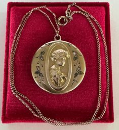 Rare and substantial antique circa 1900s Victorian era gold filled gibson girl portrait locket! This stunning pendant features a repousse woman's portrait facing to the right with ten clear paste stones, she's holding a flower with a green stone in the center. The locket hangs from its original chain. A phenomenal piece of fine Victorian jewelry, featuring a beautiful gibson girl!  ERA - Circa 1900s - Victorian  METAL / MATERIAL - Gold filled, rhinestone paste stones MARKINGS / HISTORY - Chain is marked Barrows 12k 1/15  (Barrows Jewelry is one of the oldest and most respected  jewelry stores in the country. They have been in business since 1851) CONDITION - Good antique condition. Gold filled metal has been polished & cleaned. Very little age appropriate patina & wear remains - a few mino Antique Medallion Necklace With Locket, Antique Medallion Locket Necklace Stamped 14k, Antique Medallion Locket Necklace, Victorian Filigree Yellow Gold Locket Necklace, Victorian Yellow Gold Locket Necklace With Filigree, Victorian Medallion Locket Necklace With Vintage Charm, Victorian Filigree Locket Necklace In Yellow Gold, Antique Yellow Gold Medallion Locket Necklace, Victorian Medallion Locket Necklace Hallmarked