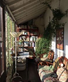 a porch with lots of furniture and bookshelves full of books, plants on the wall