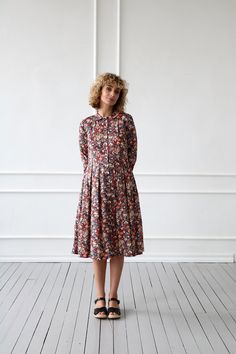 "Midi-length dress made in a soft and lightweight tana lawn cotton fabric. Fitted bodice, with a rounded peter pan collar, button closure down the front. Pleats in to waist. Bracelet-length sleeves with double-buttoned cuffs. - Handmade in our studio from 100% Liberty Tana Lawn cotton - Fitted bodice, half-length buttons closure, pleats into waist - Peter pan collar - Bracelet-length sleeves - Buttons opening at the front - Pleated skirt with side pockets FABRIC&CARE Fabric of dress behaves Spring Cotton Dress With Long Sleeves, Cotton Dress For Daywear In Fall, Cotton Long Sleeve Dress For Daywear, Casual Long Sleeve Cotton Dresses, Fitted Long Sleeve Cotton Dress, Relaxed Fit Cotton Floral Print Dress, Fall Floral Print Cotton Dress, Fall Cotton Dress With Floral Print, Fall Cotton Floral Print Dress