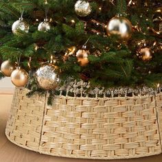 a christmas tree in a wicker basket with ornaments on it's top and bottom