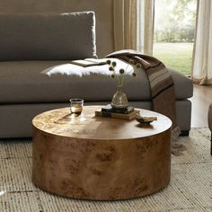 a living room with a couch, chair and coffee table in front of a window