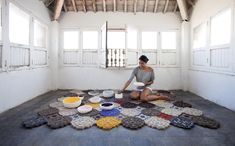 a woman sitting on the floor with bowls and plates