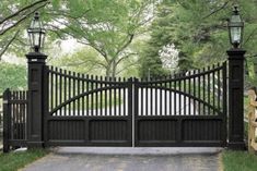 an iron gate with two lights on each side and a light post at the end