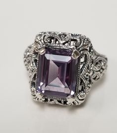 "Thanks for shopping our vintage estate store. We tend to sell well below wholesale and truly hope you enjoy all of our items. Many of the items are one of a kind, so please enjoy scrolling through the pictures and hopefully something will catch your eye. Brown spots are from camera or reflections. Estate Sterling Silver 925 blue 4ct Alexandrite stone ring in a vintage setting. This is a custom ring made in our shop, meaning we added the alexandrite. Gem is blue in color created or imitation, bu Vintage Emerald Cut Amethyst Ring For Anniversary, Vintage Emerald-cut Amethyst Ring For Anniversary, Vintage Emerald Cut Amethyst Ring Gift, Vintage Amethyst Ring With Accent Stones, Vintage Stamped 925 Topaz Ring Gift, Vintage Sterling Silver Topaz Collectible Ring, Vintage Silver Amethyst Ring With Accent Stones, Vintage Amethyst Ring With Accent Stones For Collectors, Vintage Stamped 925 Amethyst Ring