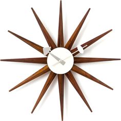 a clock that is on the wall and has wooden sticks sticking out of it's face