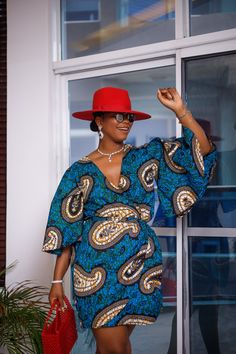 A woman posing in a blue and tan African print mini dress. She is pictured from the waist up and smiling. She is styled with a red beaded purse Afro Design, Hebrew Women, African Print Dress Designs, Stylish Work Attire, Ankara Print, African Ankara, Classy Design, Design Dresses, African Print Dress