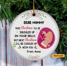 a christmas ornament hanging from a tree with an image of a baby on it