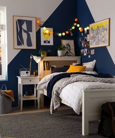 a bedroom decorated in blue and yellow with pictures on the wall above the bed, along with an area rug