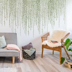 a living room with a couch, chair and potted plant on the wall in front of it