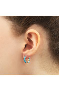 Easy-to-wear hoop earrings will add significant polish to even your most casual ensembles. 1/2" drop; 1/8" width Hinge with snap-post closure Sterling silver with goldtone plate/enamel Imported Small Hoop Enamel Earrings, Hoop Huggie Earrings In Enamel, Blue Huggie Hoop Earrings For Pierced Ears, Everyday Enamel Hoop Earrings, Blue Huggie Single Earring, Trendy Blue Enamel Jewelry, Enamel Huggie Hoop Earrings For Pierced Ears, Blue Hypoallergenic Small Hoop Huggie Earrings, Blue Huggie Earrings For Everyday