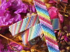 a crocheted tie sitting on top of flowers next to purple and yellow leaves