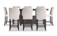 a dining room table and chairs with white linen upholstered backrests on each side