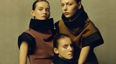 three models pose for the camera in front of a gray background, wearing brown and black clothing