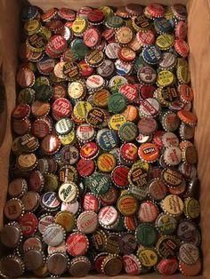 a box filled with lots of different types of beer bottle caps on top of each other