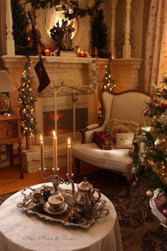 a living room decorated for christmas with candles and stockings on the fireplace mantels