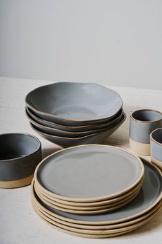 a table topped with plates and bowls next to each other