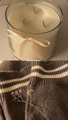 a candle that is sitting next to a sweater