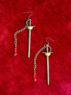 Based off the song built by nations by Greta van fleet  Using large brass swords, gold chain and red beads and 925 Ear wires Greta Van Fleet, Aesthetic Gift, Wounded Warrior, Red Beads, Boho Aesthetic, Aesthetic Rooms, Inspired Jewelry, Red Bead, Jewelry Handmade