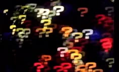 many question marks are seen in this blurry photo, and they appear to be multicolored