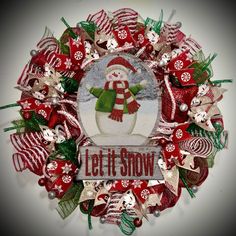 a red and white wreath with a snowman on it that says let it snow