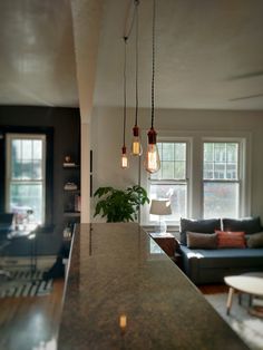 a living room filled with furniture next to a kitchen and dining room table in front of a window