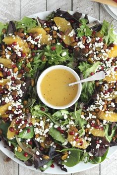 a salad with dressing in a bowl on a white plate next to an orange slice